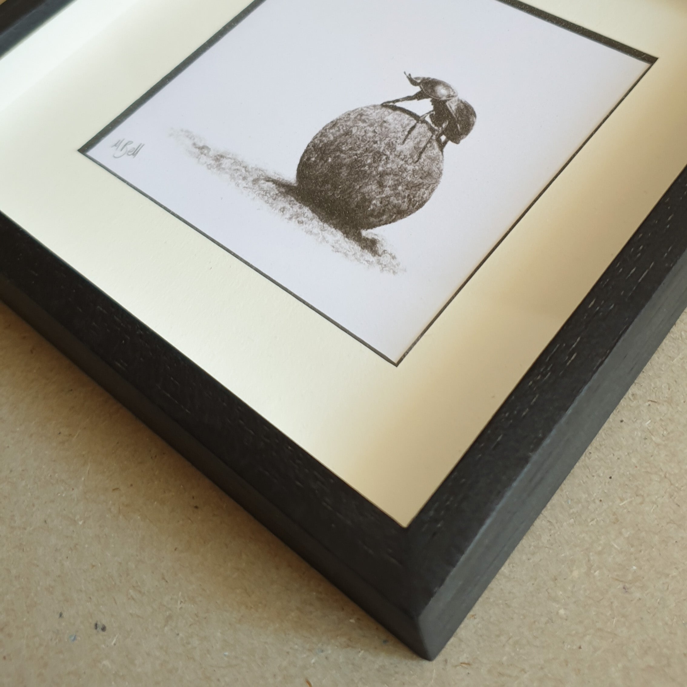 Dung beetle artwork with black wood frame