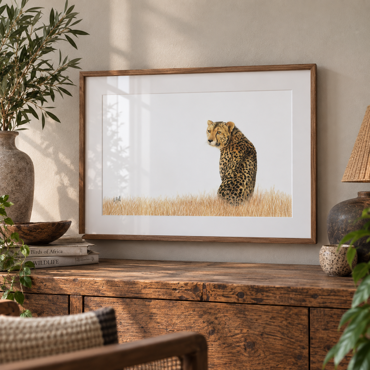 Cheetah drawing by South African wildlife artist Matthew Bell, with a kiaat frame hanging on the wall with decor and plants around it