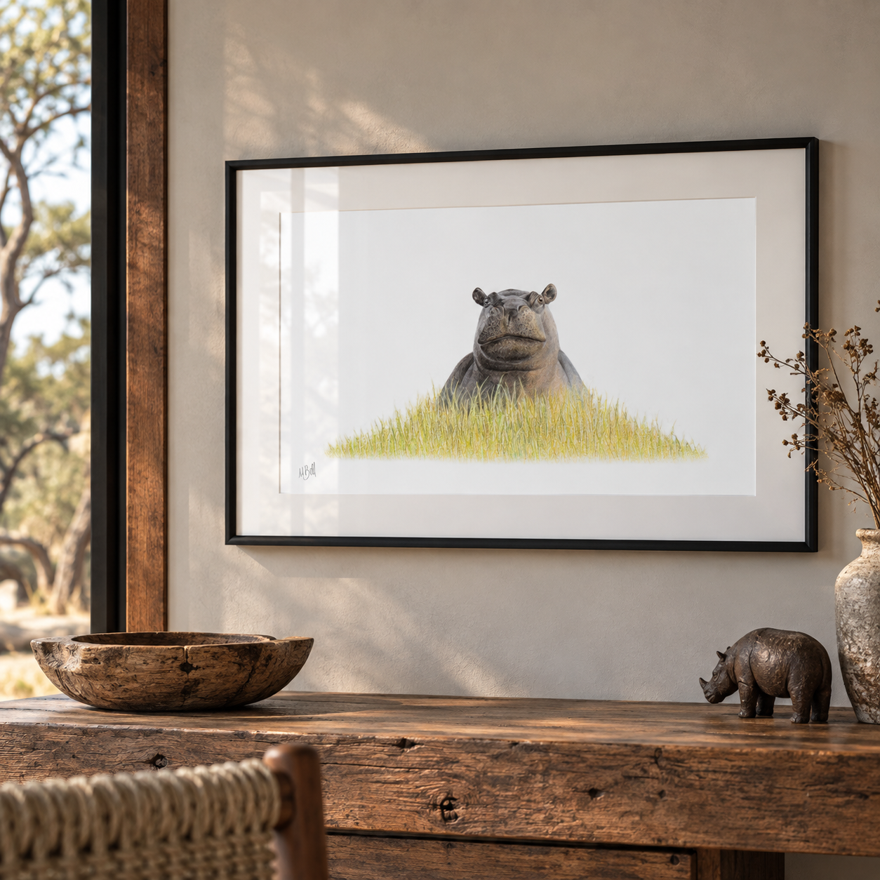 Framed artwork of a hippo in a wetland hanging on the wall in an African safari themed room