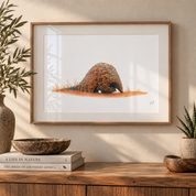 Framed Pangolin artwork hanging on the wall in a warm interior above a wooden counter top