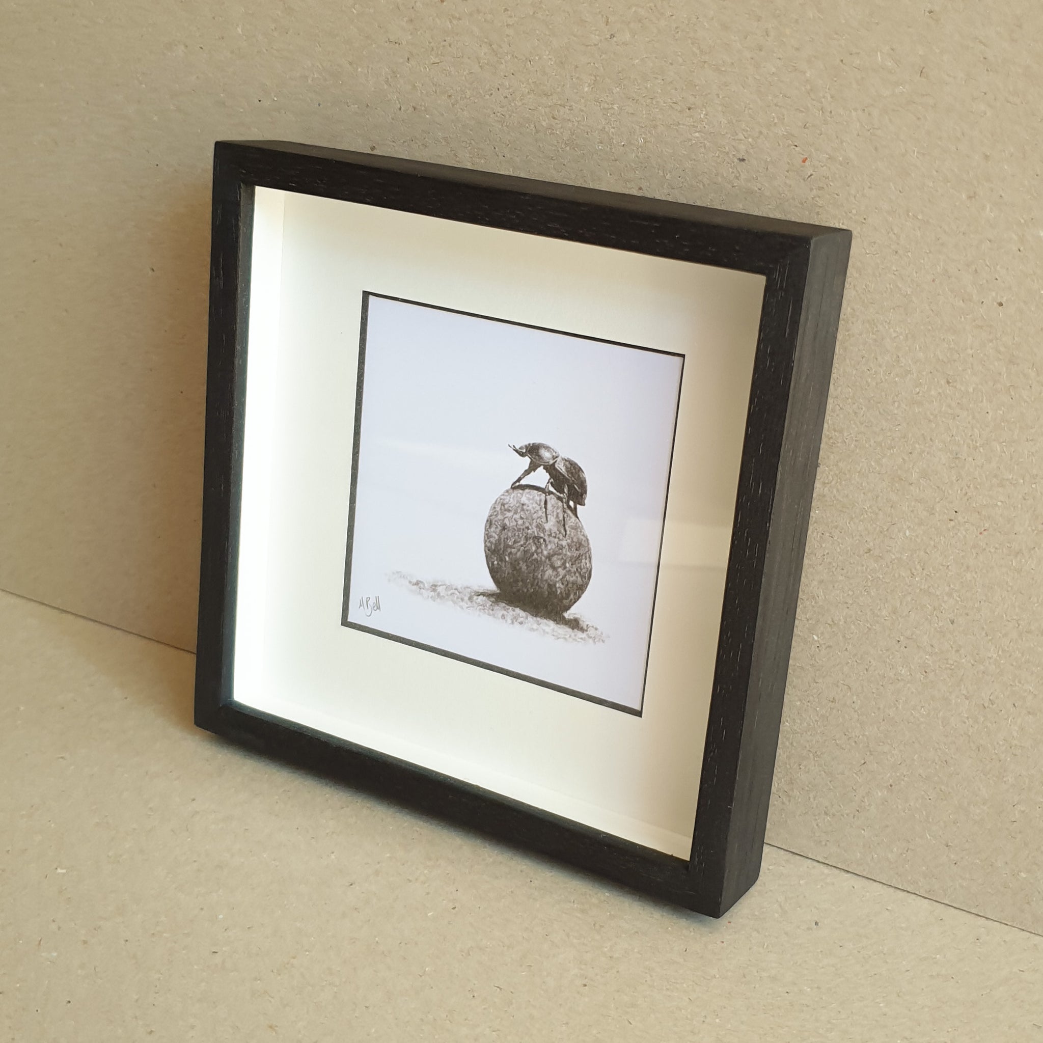 Dung beetle artwork with black wood frame